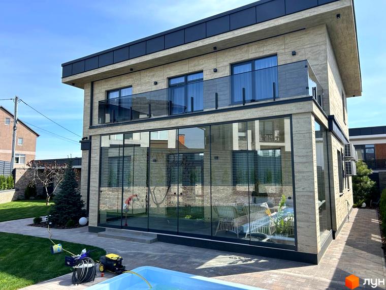 Зовнішній вигляд будинку Комплекс Грушевий з великими вікнами та балконами, прибудинкова територія з зеленими насадженнями.