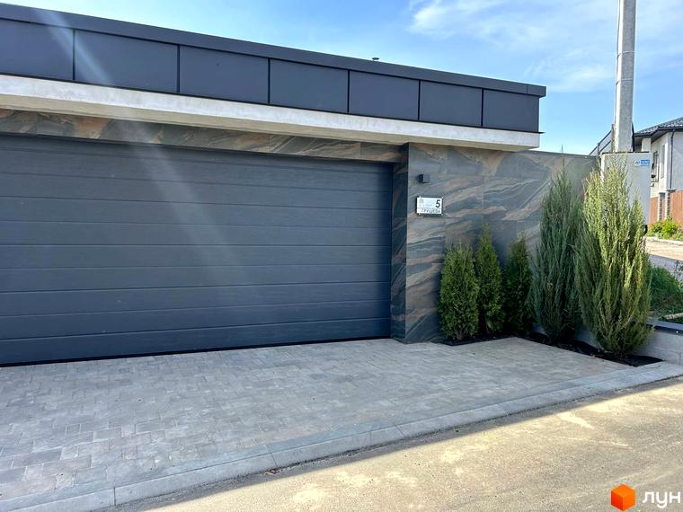 Вхід до житлового комплексу Комплекс Грушевий з сучасними елементами. Прибудинкова територія з зеленими насадженнями та вимощеною доріжкою.