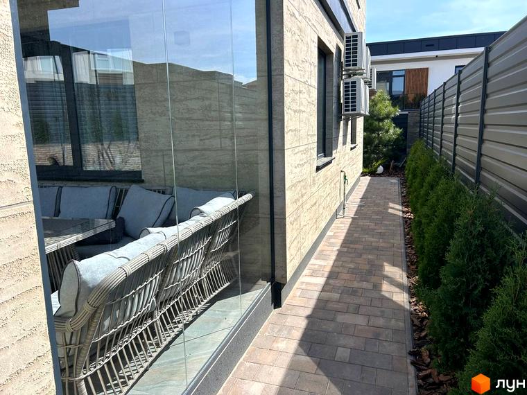 Зовнішній вигляд будинку Комплекс Грушевий з терасою та прибудинковою територією, викладеною плиткою та озелененням.