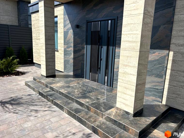 Вхідна група житлового комплексу Комплекс Грушевий з гранітними сходами та сучасним фасадом. Прибудинкова територія озеленена та впорядкована.