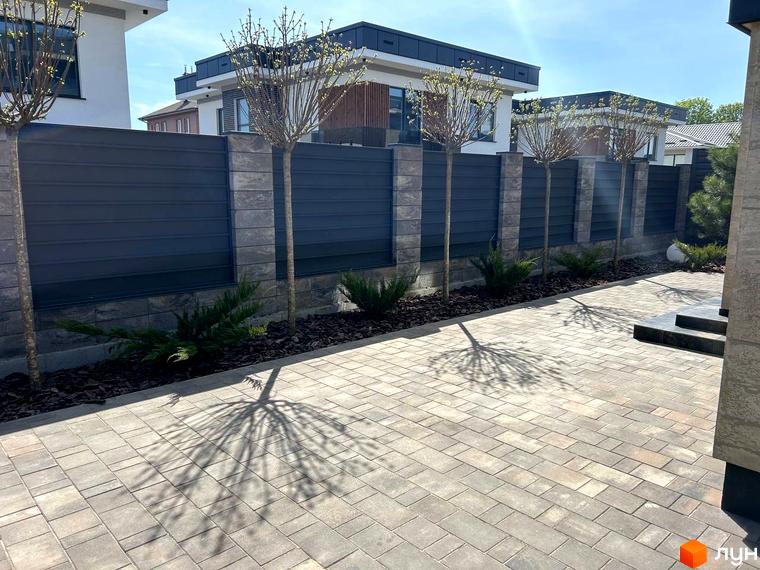 Зовнішній вигляд будинків житлового комплексу Комплекс Грушевий з прибудинковою територією, викладеною плиткою та деревами.