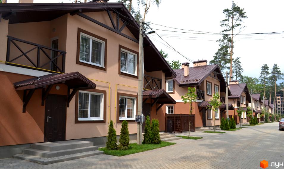 Котеджне містечко Sweet Home: ряд двоповерхових будинків світло-коричневого кольору з темними дахами та доглянутою прибудинковою територією.