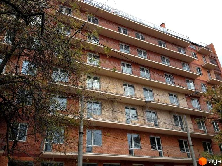 Зовнішній вигляд багатоквартирного будинку ЖК Родной з цегляним фасадом та балконами. Фото новобудови.