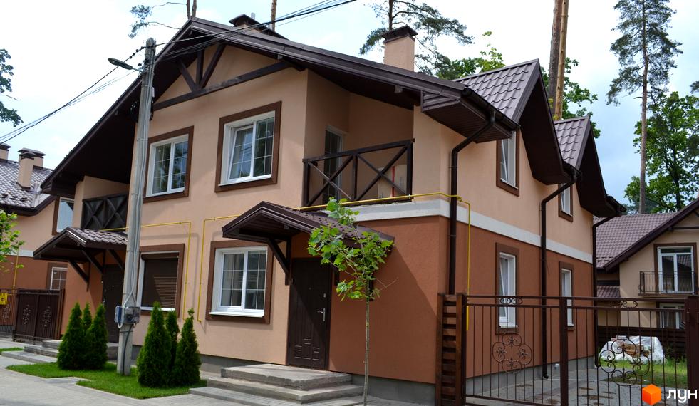 Котеджне містечко Sweet Home: будинки з коричневими дахами, світло-коричневими фасадами та білими вікнами. Прибудинкова територія з бруківкою та зеленими насадженнями.