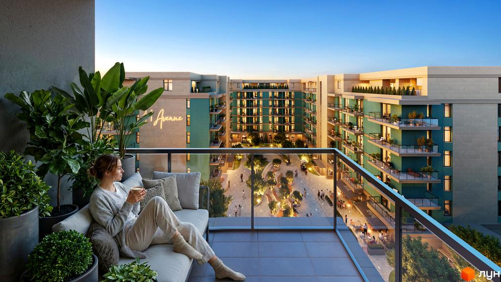 Вид з балкона Житлового комплексу 44 Avenue на будівлі з бірюзовими фасадами та внутрішній двір з освітленням, деревами та закладами.