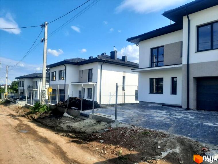 Зовнішній вигляд будинків у житловому комплексі КМ Savanna, прибудинкова територія з підготовленим тротуаром.