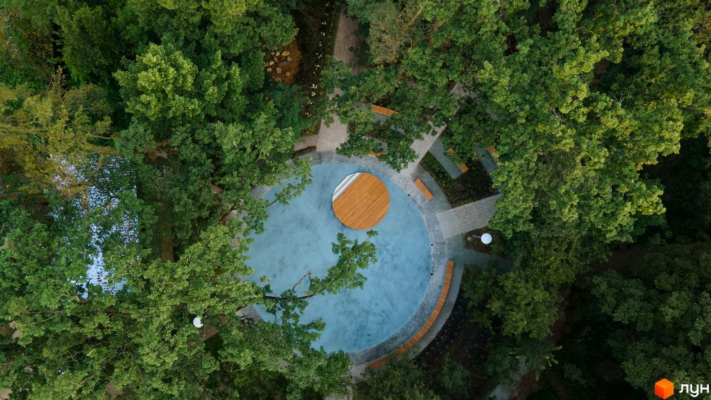 Вид на прибудинкову територію ЖК Chalet з круглою зоною відпочинку та зеленими насадженнями.