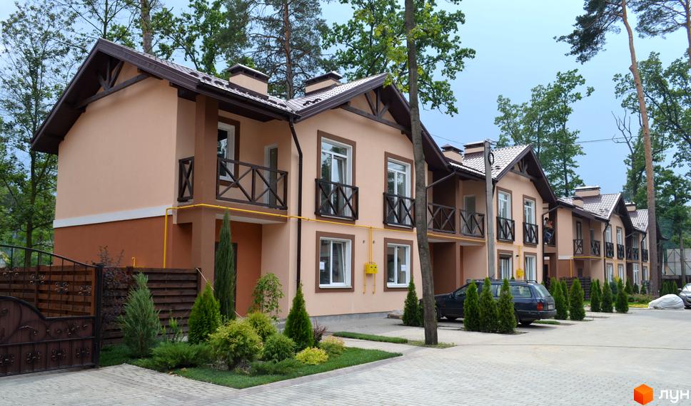 Котеджне містечко Sweet Home: двоповерхові будинки з бежевими фасадами та балконами. Прибудинкова територія з бруківкою та озелененням.