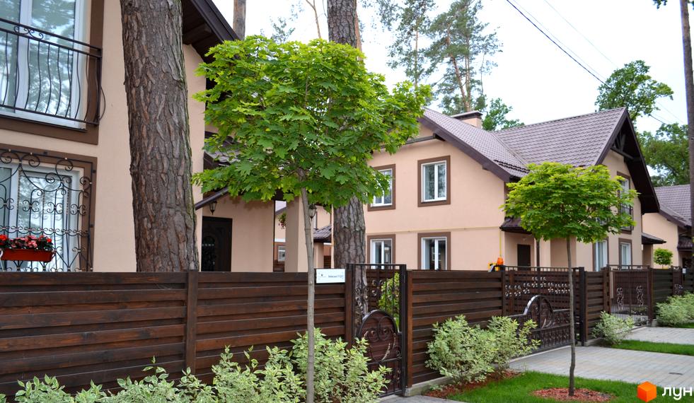 Котеджне містечко Sweet Home: двоповерхові будинки зі світлим фасадом, коричневим дахом, дерев'яним парканом та озелененою територією.