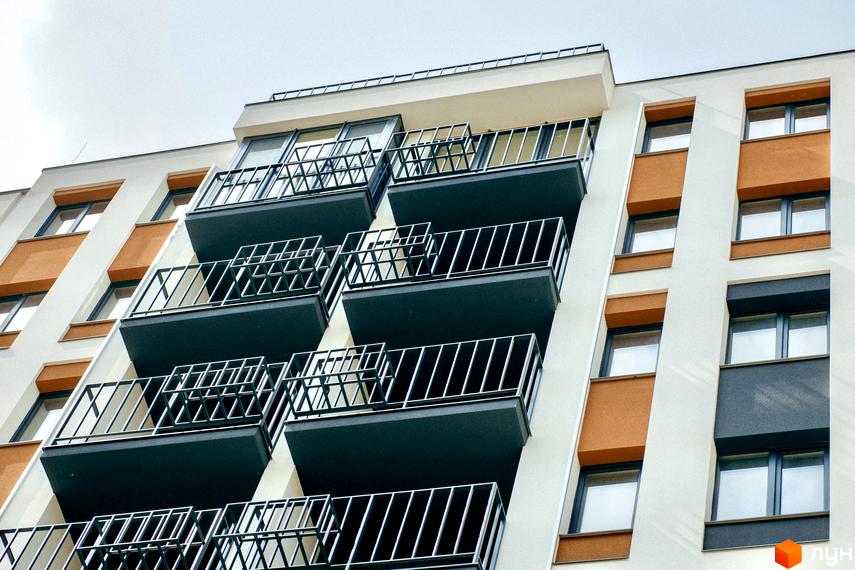 Зовнішній вигляд новобудови ЖК КЕЛЬЦЕ з балконами та вікнами. Комплекс має біло-помаранчеве оздоблення фасаду.