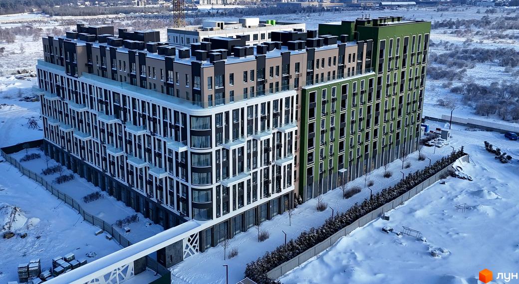 Новобудова ЖК PARK ROYAL з фасадами чорного, бежевого та зеленого кольорів, розташована на засніженій території з деревами та парканом.