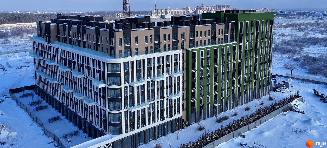 Новобудова ЖК PARK ROYAL з фасадами білого, бежевого та зеленого кольорів, розташована на засніженій території з деревами.