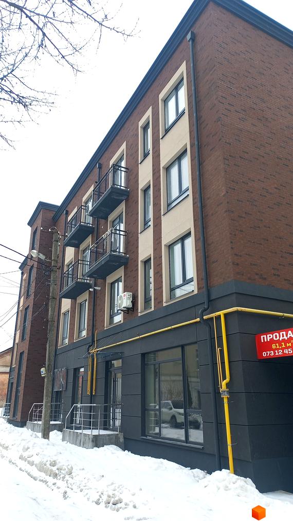 Зовнішній вигляд цегляного будинку з балконами та великими вікнами на вулиці Вагилевича, 9. Навколо будівлі багато снігу, що свідчить про зимовий період.
