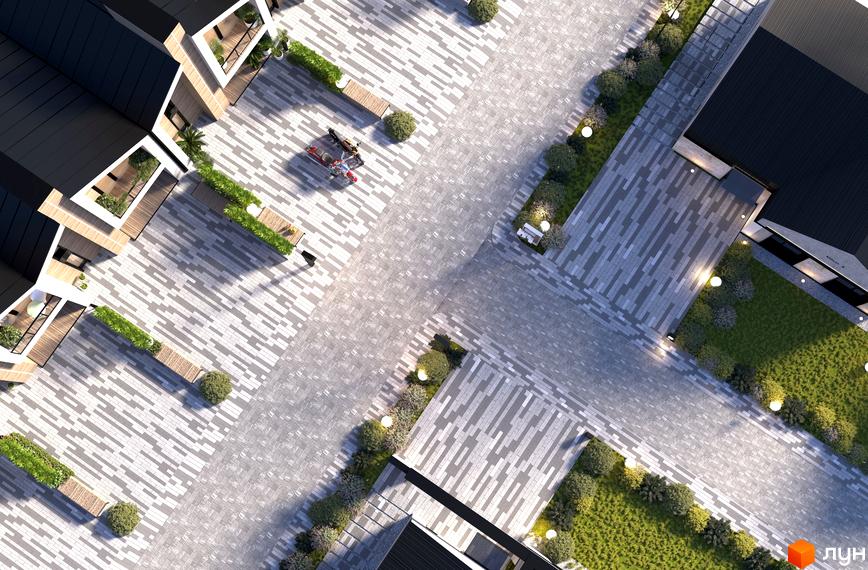 Котеджне містечко KOLO 32: вид зверху на будинок з чорним дахом та прибудинкову територію з бруківкою та зеленню.