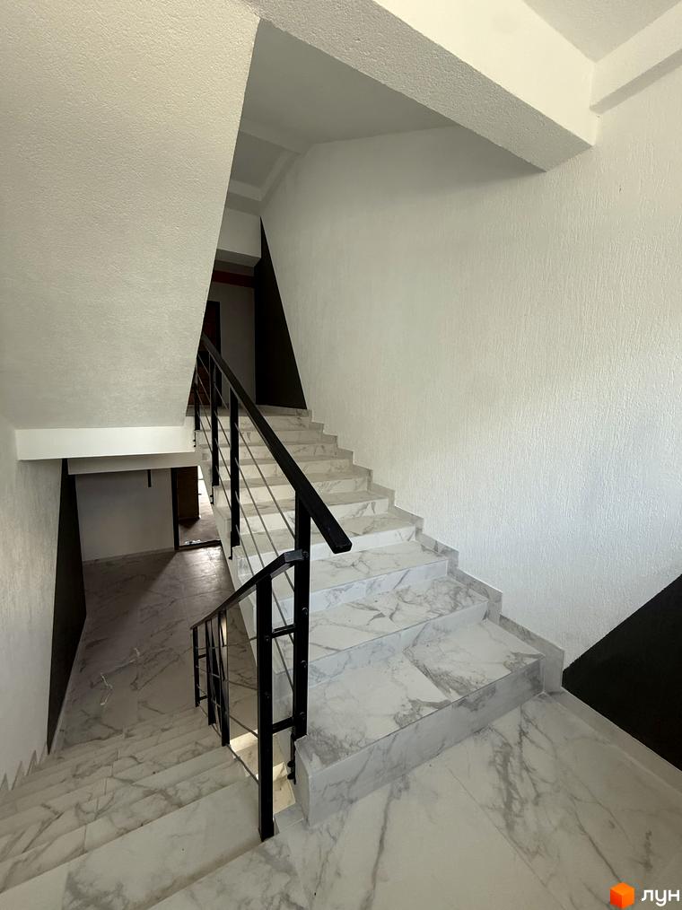 Сходи в ЖК Brickwood 2 з мармуровими сходами та чорними поручнями. Внутрішній вигляд новобудови.