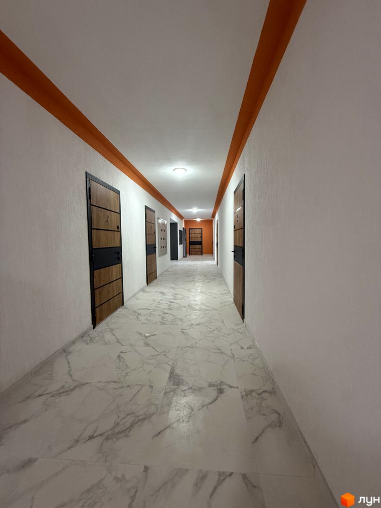 Коридор новобудови ЖК Brickwood 2 з дверима та мармуровою підлогою. Огляд внутрішнього простору житлового комплексу.