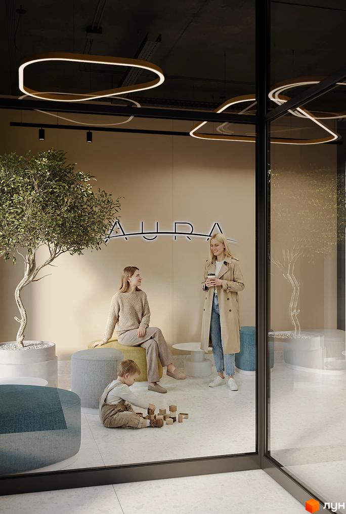 Житловий комплекс AURA: сучасна зона відпочинку з дитиною та двома жінками біля стіни з написом 