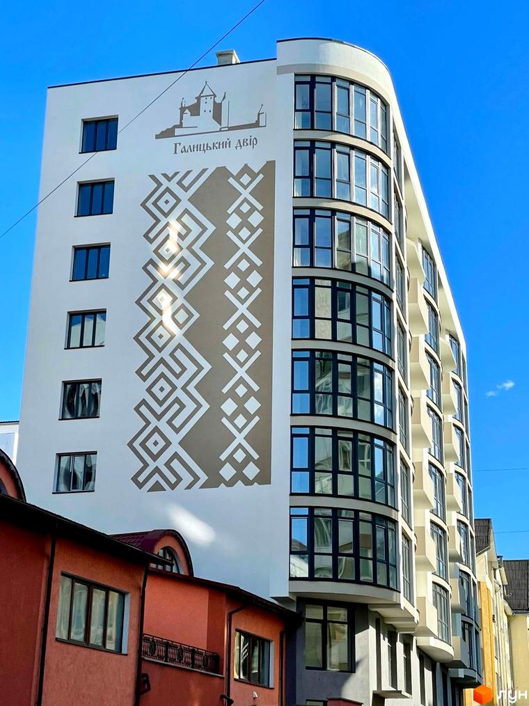 Зображення фасаду житлового комплексу Галицький двір на вул. Володимира Великого, 16 з геометричним орнаментом та панорамними вікнами.