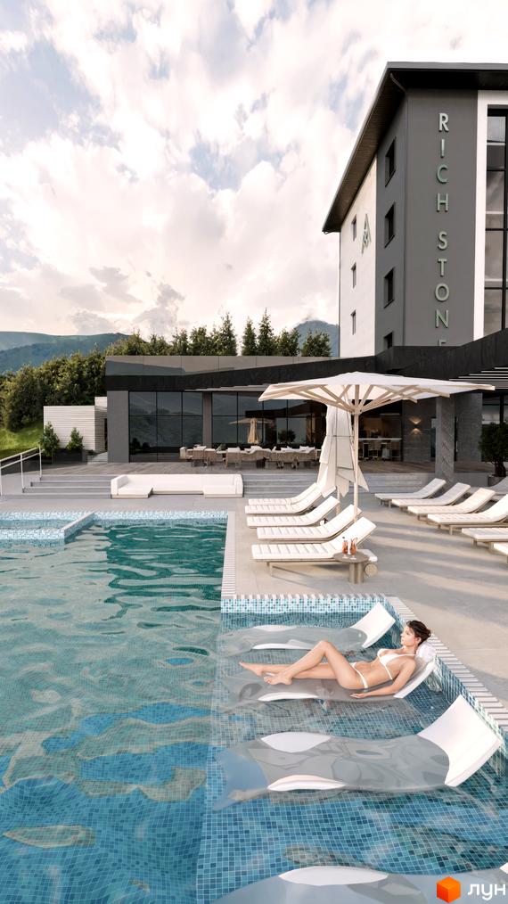 Апарт-готель Rich Stone Family Club з сірим фасадом та великими вікнами. На передньому плані басейн з блакитною плиткою та зоною відпочинку.
