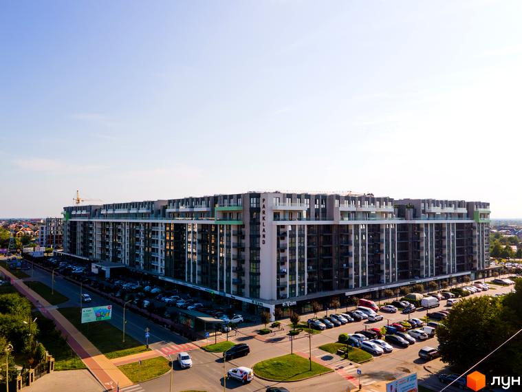 Зовнішній вигляд житлового комплексу PARK LAND з багатоповерховими будинками та прибудинковою територією з парковкою та дорогою.