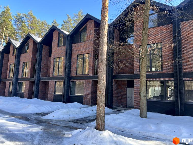 Таунхаус Forest Lane, цегляні фасади, великі вікна, зимовий пейзаж зі снігом навколо. Новобудова в оточенні дерев.