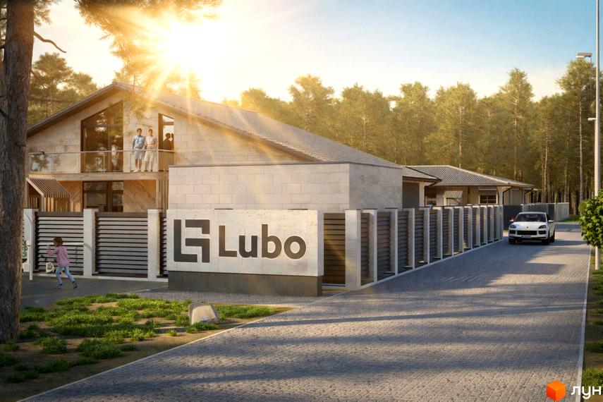 Котеджне містечко Lubo Village з кам'яними фасадами та огородженою територією, на тлі лісу. На передньому плані доріжка з бруківки та зелена зона.