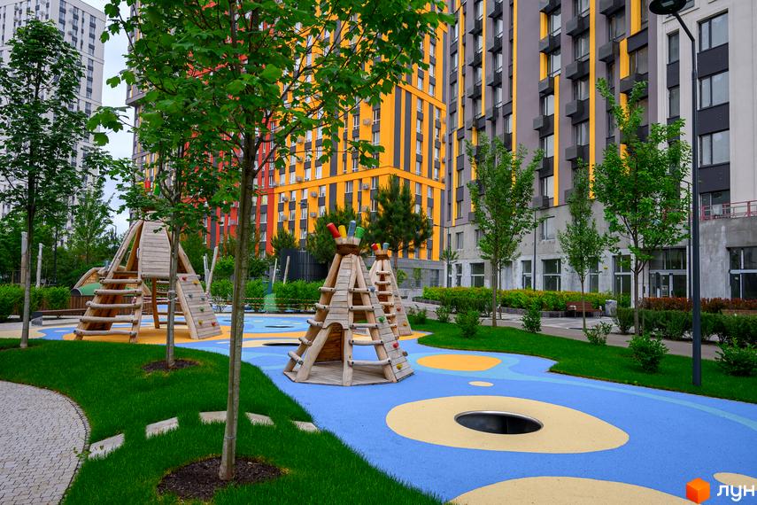 Житловий комплекс Svitlo Park з яскравими фасадами та сучасною дитячою зоною відпочинку. Зелена прибудинкова територія з елементами ландшафтного дизайну.