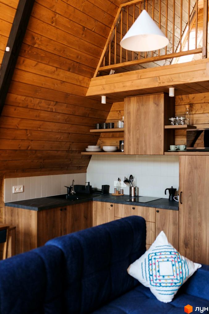 Інтер'єр кухні в дерев'яному стилі з темно-синім диваном та декоративною подушкою. Комплекс відпочинку УЛІС Ворохта.