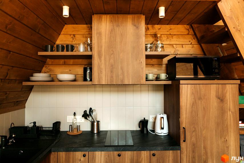 Кухня в Комплексі відпочинку УЛІС Ворохта з дерев'яними стінами та стелею, обладнана побутовою технікою та посудом.
