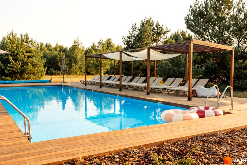 Комплекс відпочинку УЛІС Дудки з басейном та шезлонгами. Територія комплексу оточена сосновим лісом.