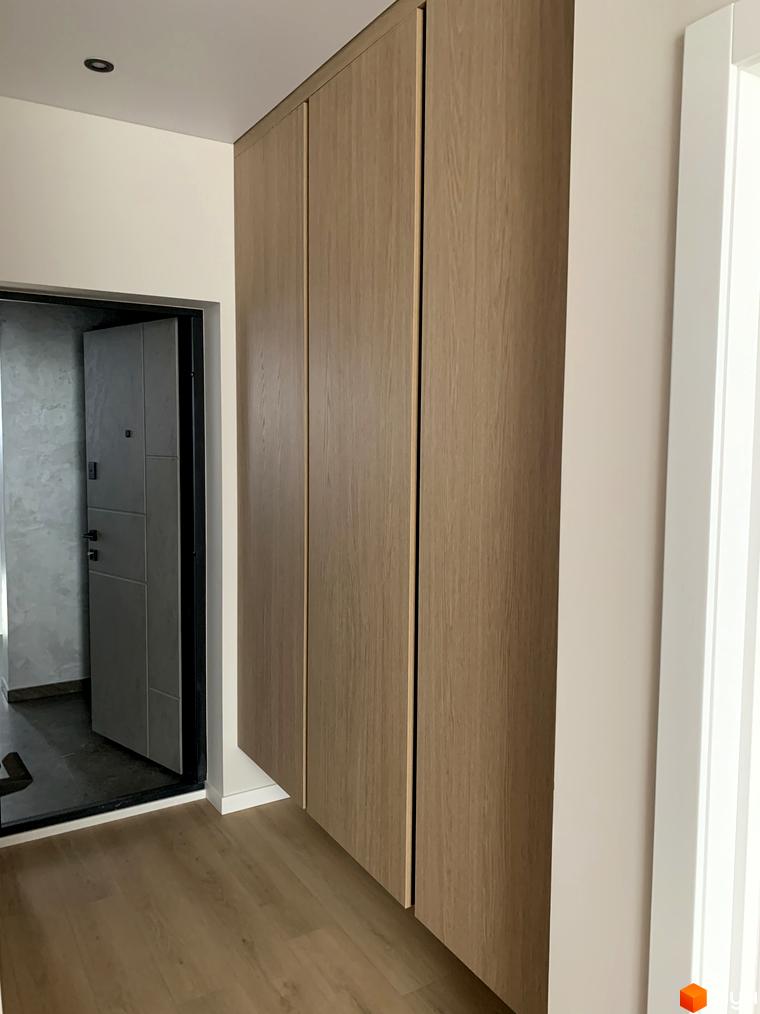 Новобудова Fine Flats: дерев'яні фасади шафи, вхідні двері та підлога в коридорі.