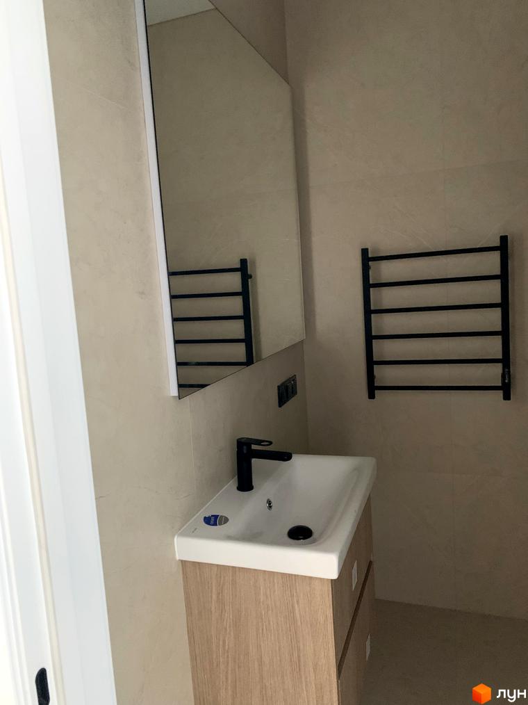 Ванна кімната у Житловому комплексі Fine Flats з білою раковиною, чорним змішувачем, дзеркалом та рушникосушаркою.