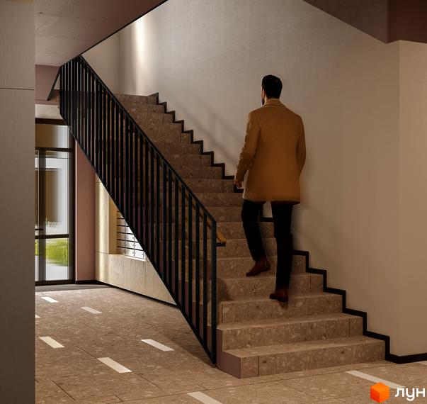 Інтер'єр холу Житлового комплексу SOFIhome з кам'яними сходами та металевими перилами. Видно чоловіка, що піднімається вгору, та великі вікна.