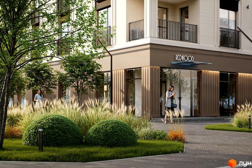 Житловий комплекс Молоді: світлий фасад, коричневий цоколь з магазином REDWOOD. Озеленена прибудинкова територія з деревами, кущами та травами.