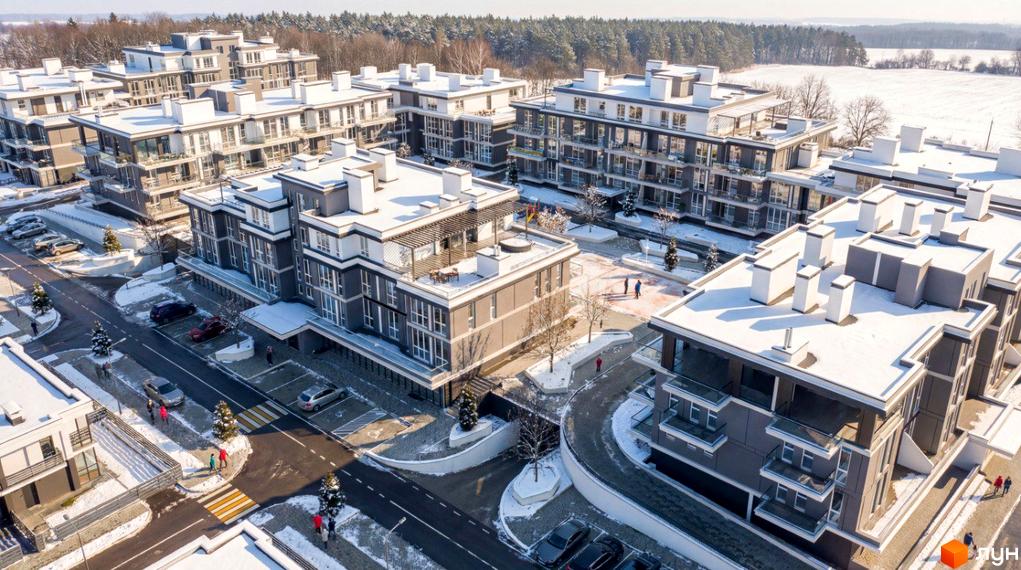 Комплекс ParkWill взимку з білим дахом та сірими фасадами, оточений деревами та снігом. На території комплексу є парковка та пішохідні доріжки.