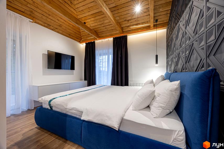 Спальня в Котеджному містечку Агат Резорт & SPA з синім ліжком, дерев'яною стелею, телевізором та декоративною стіною.