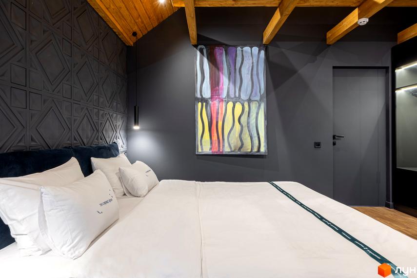 Спальня в Котеджному містечку Агат Резорт & SPA з ліжком, темними стінами, дерев'яною стелею та картиною.