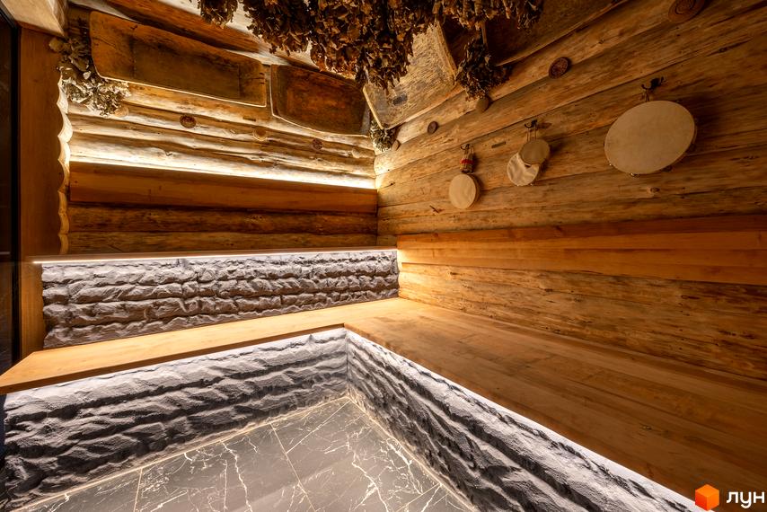 Інтер'єр SPA зони в КМ Агат Резорт & SPA з дерев'яними лавами та кам'яною обробкою стін. Затишна атмосфера для відпочинку та релаксації.