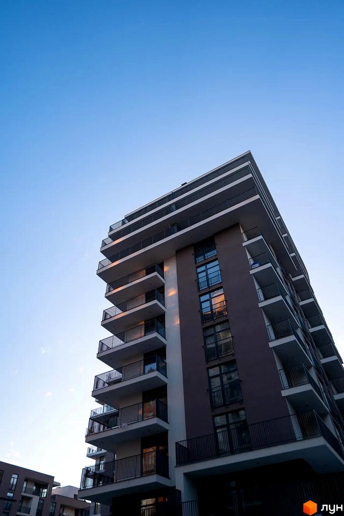 Зовнішній вигляд новобудови ЖК Crystal з численними балконами та вікнами на тлі блакитного неба. Зовнішній вигляд новобудови ЖК Crystal.