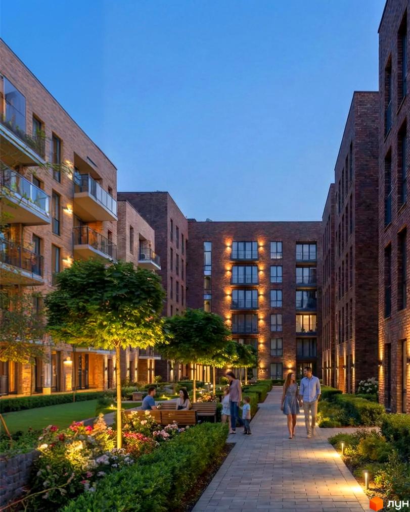 Житловий комплекс Nord-Wood з цегляними фасадами та балконами, освітлений ввечері. Прибудинкова територія з доглянутими зеленими насадженнями та доріжками.
