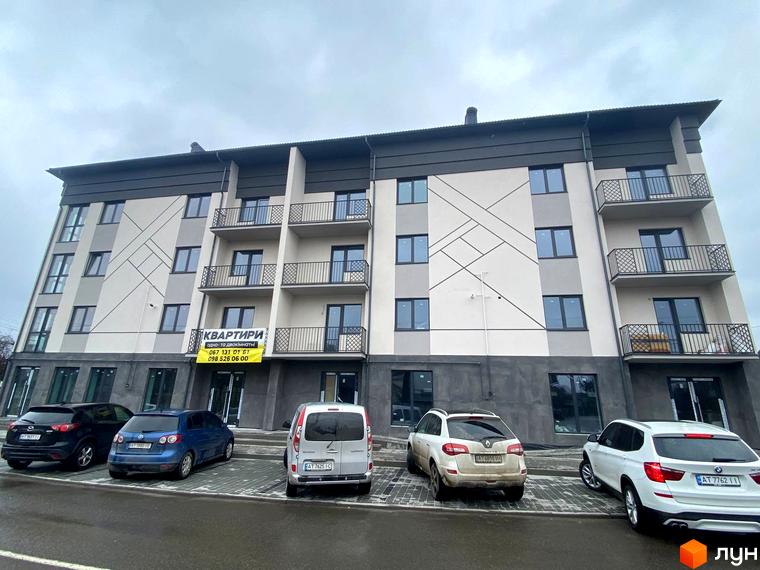 Багатоповерховий житловий будинок на вул. Гетьманська, 41 зі світлим фасадом, сірими вставками та балконами. Перед комплексом облаштована парковка з автомобілями.