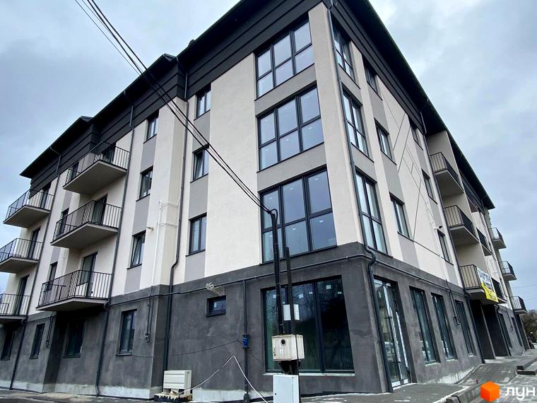 Житловий будинок на вул. Гетьманська, 41 з сіро-бежевим фасадом, балконами та великими вікнами. На першому поверсі комерційні приміщення, поруч тротуар.