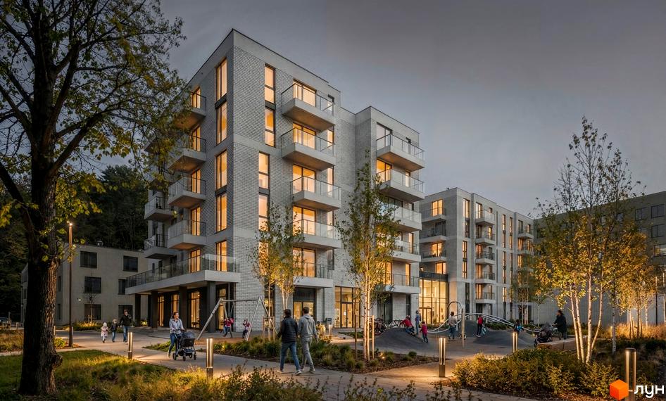 Житловий комплекс на Замарстинівській, 83б: багатоповерхові будинки зі світло-сірої цегли, балконами та освітленим двором з дитячим майданчиком.