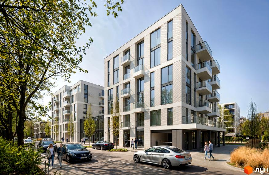 Фасад Житлового комплексу на вул. Замарстинівська, 83б з світлої цегли, великими вікнами та скляними балконами. Навколо зелені дерева, дорога та пішоходи.