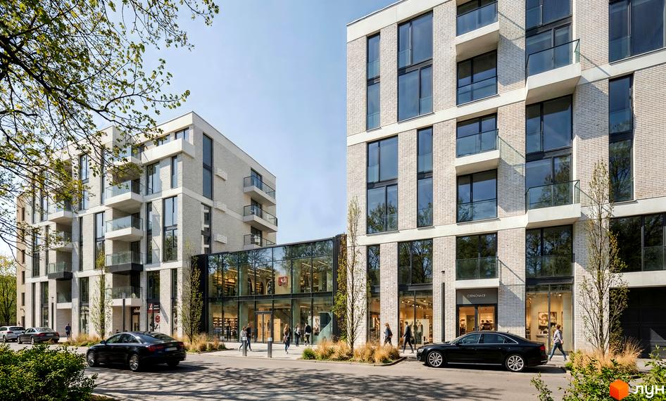 Фасад житлового комплексу на вул. Замарстинівська, 83б з світлої цегли, великими вікнами та скляними балконами. На першому поверсі комерційні приміщення, поруч дорога та зелені насадження.