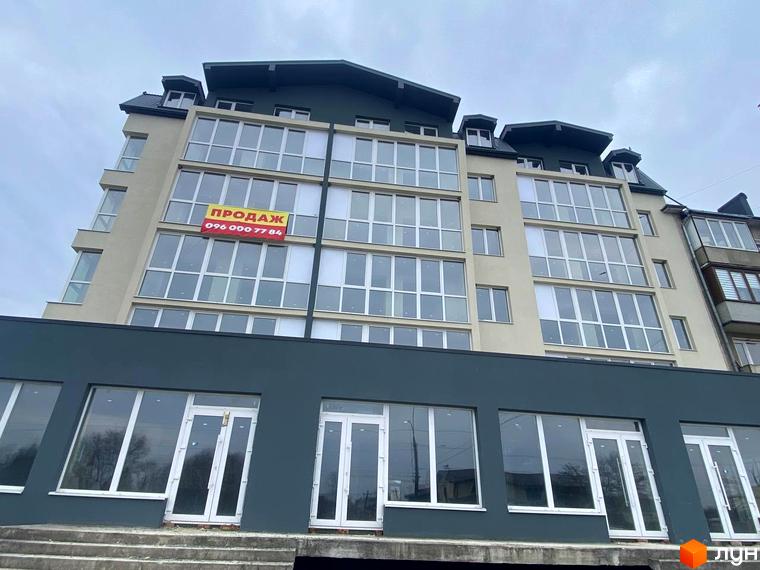 Багатоповерхова новобудова на вул. Карпатська, 163 з світлим фасадом, великими вікнами та комерційними приміщеннями на першому поверсі.