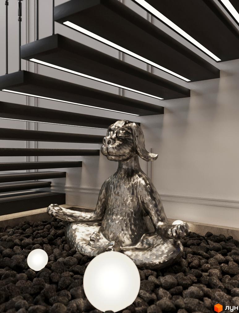 Інтер'єр OLEGIV Boutique Residence з дерев'яними сходами та лінійним підсвічуванням. Під сходами розміщено срібну статую собаки на гальці з підлоговими світильниками.