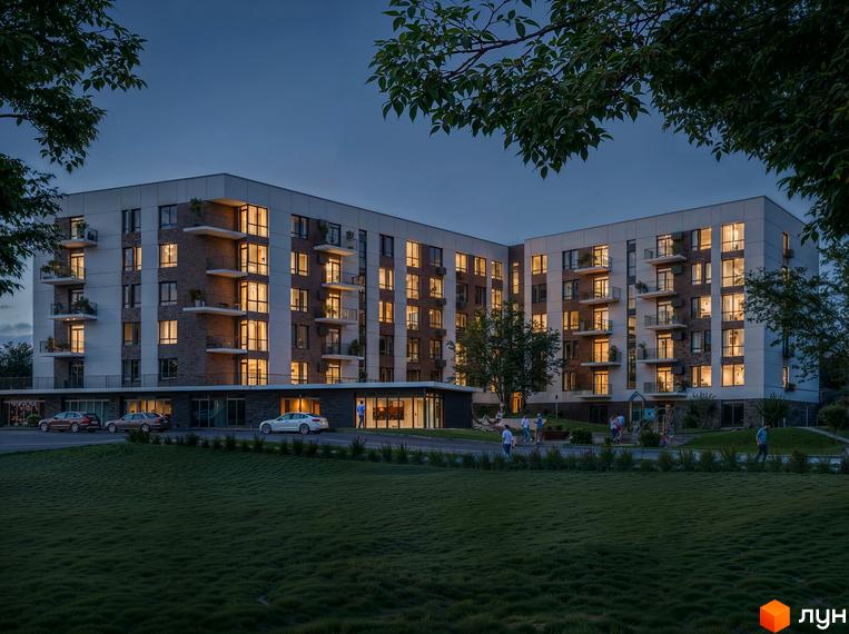 Житловий комплекс Silver Hill ввечері з освітленими вікнами, балконами та цегляними фасадами. Поруч зелений газон, дорога з автомобілями та дитячий майданчик.