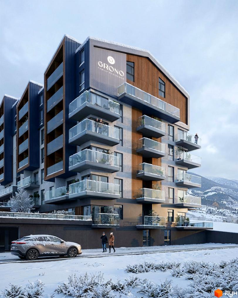 Житловий комплекс GRONO Family Residence: багатоповерховий будинок з темно-синім та дерев'яним облицюванням, скляними балконами. Зображено засніжену територію з дорогою та горами.
