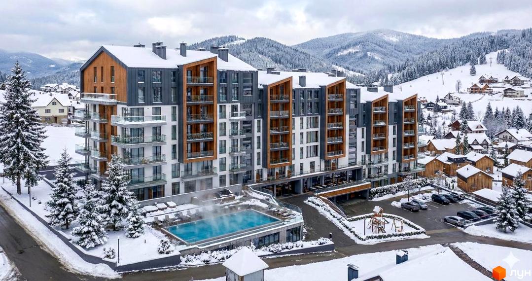 Житловий комплекс GRONO Family Residence з фасадами з дерева та сірих панелей. На засніженій території: відкритий басейн, майданчик, паркінг.